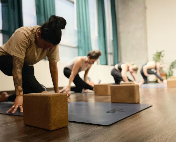 Yoga teacher training students in half-splits pose.