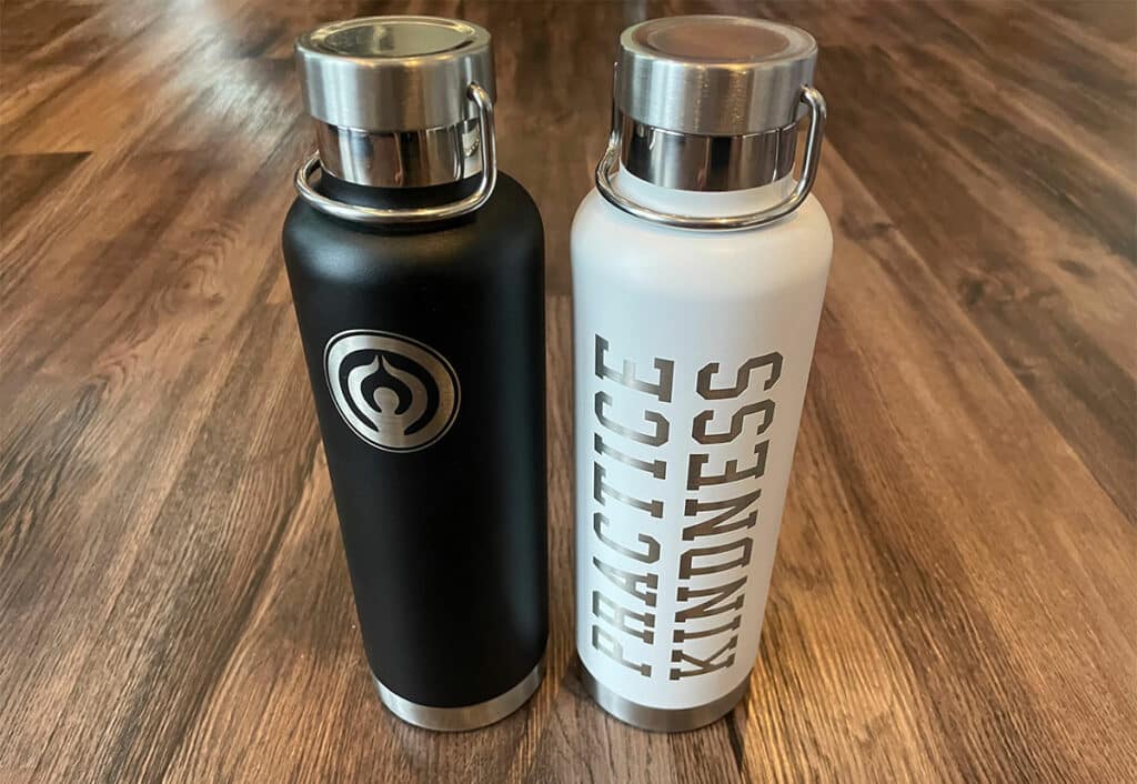 Black or white options for water bottles, featuring the Firelight Yoga brand image along with the words "practice kindness".