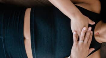 Person laying down with hands on heart, resting.